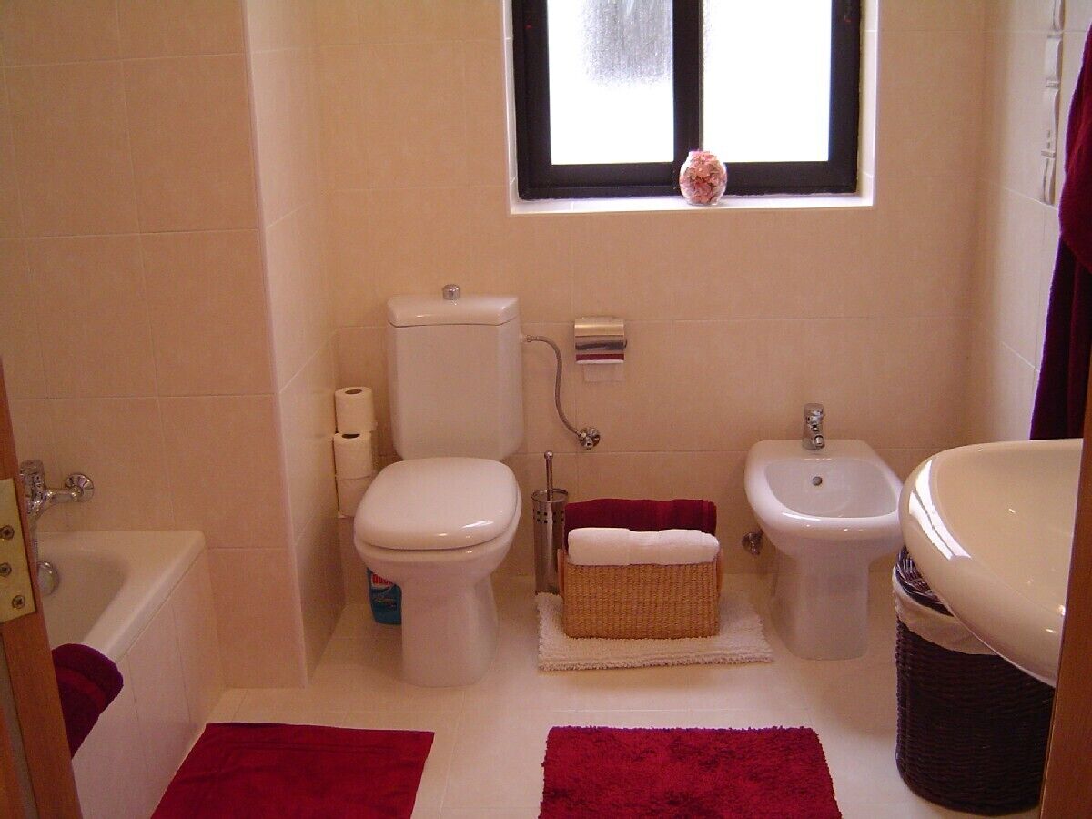 Une salle de bain comprenant des toilettes, un bidet, une baignoire et un lavabo.