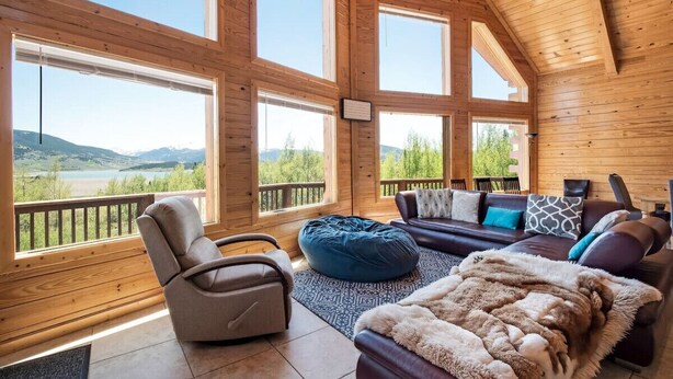 A spacious room with large windows, a comfortable seating area, and a view of the outdoors. - Huge Mountain Ski & Hike - Wildernest Haven (Silverthorne)