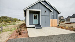 Een modern gelijkvloers huis met een grijze gevel, een blauwe voordeur en een klein voortuintje.