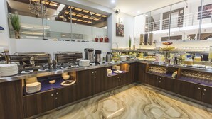 A modern kitchen with marble flooring, stainless steel appliances, and a variety of food items displayed on the counter. - Gran Recreo Hotel (Trujillo)