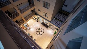 A multi-level atrium with a central seating area, multiple floors, and a staircase. - Gran Recreo Hotel (Trujillo)