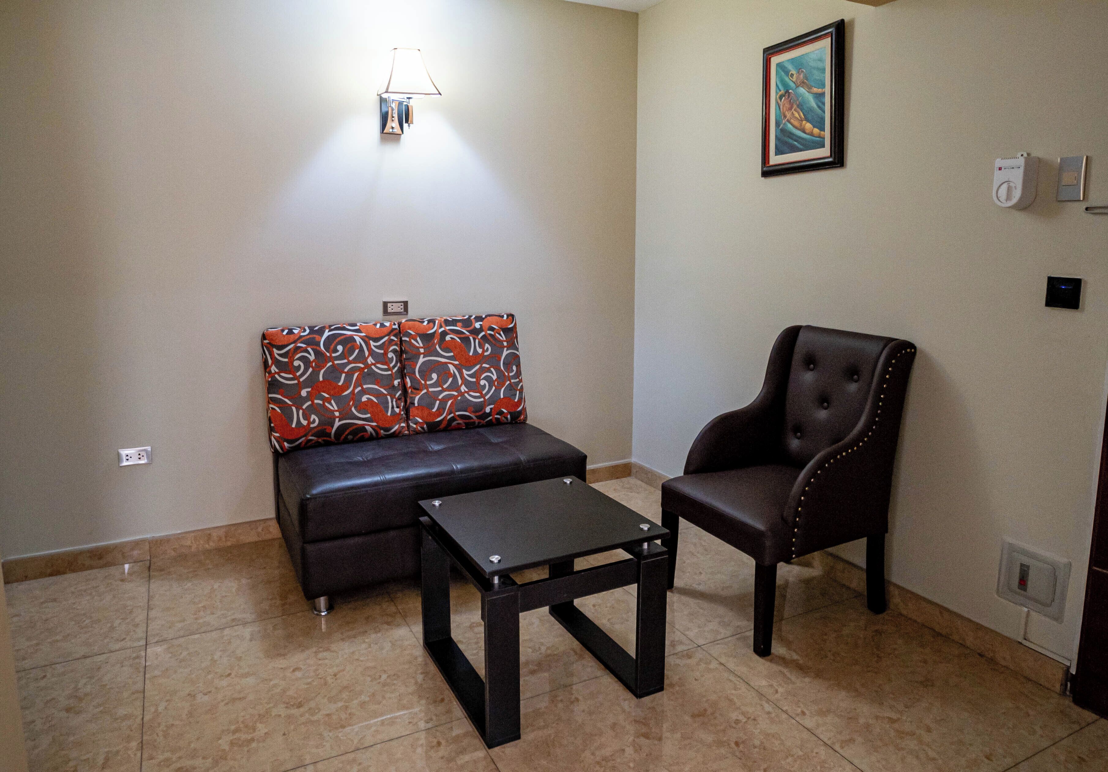 Uma sala de estar com sofá, poltrona e mesa de centro.