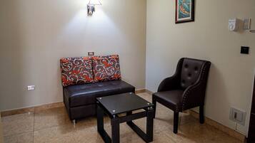 Uma sala de estar com sofá, poltrona e mesa de centro.