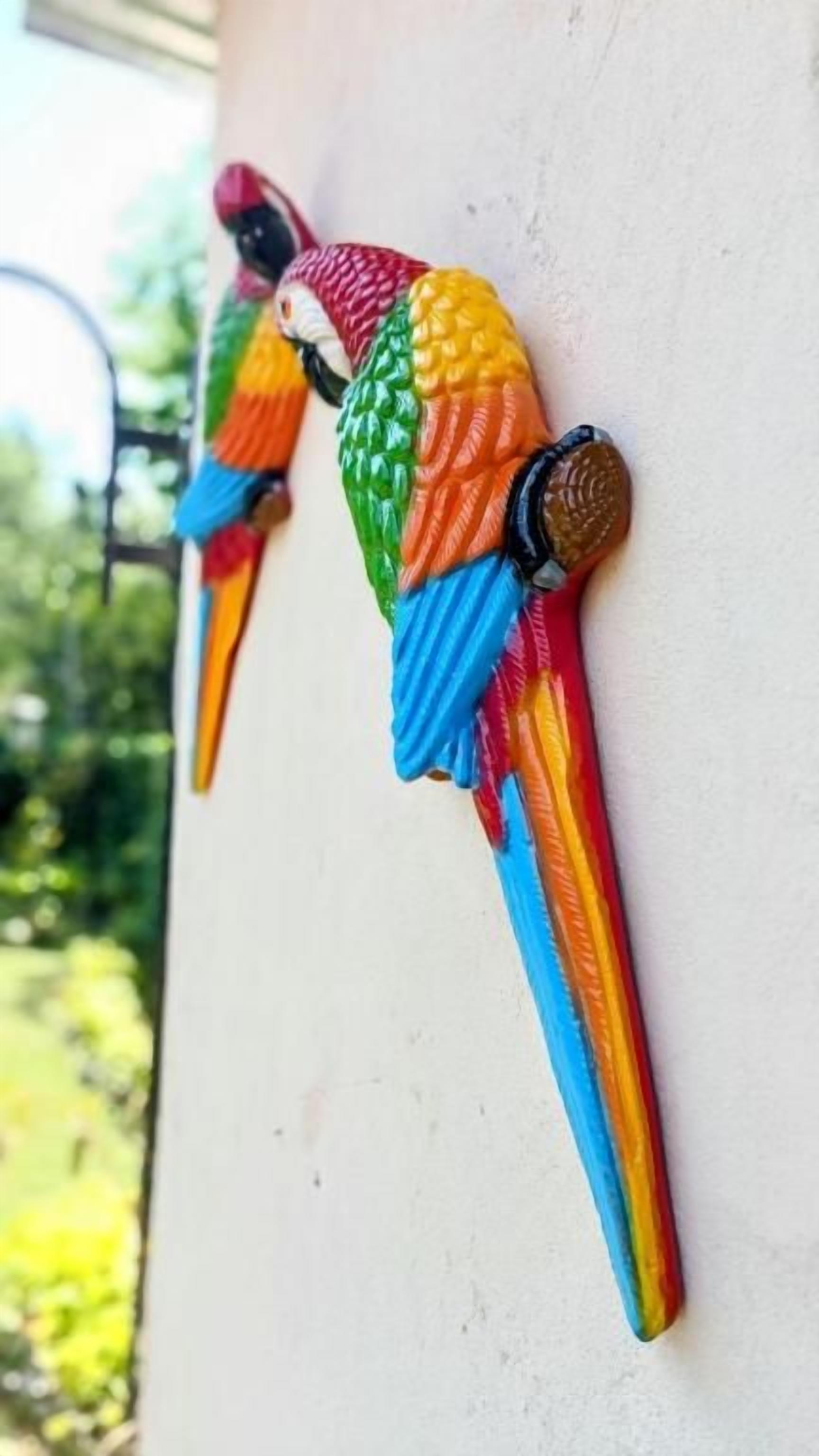 Dos decoraciones con forma de pájaro, de colores, en una pared.