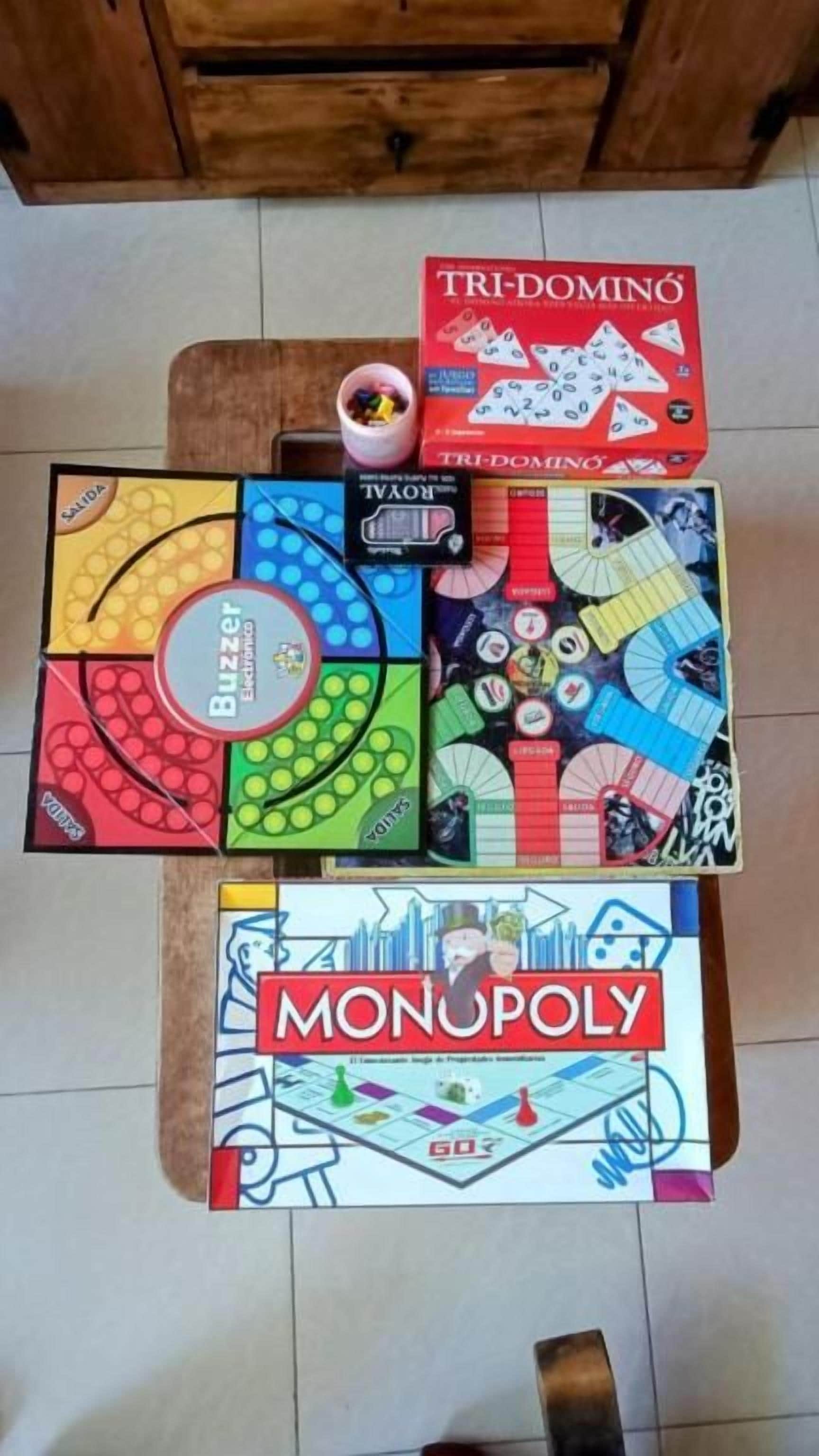 Taula amb diversos jocs de taula, incloent Monopoly i Tri-Domina.