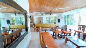 Una habitación con cama, una mesa de comedor, sillas, una zona de cocina y ventanas amplias.