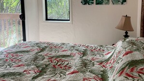 A bedroom with a bed, a window, and a ceiling fan.