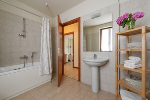 Tina con regadera, secadora de cabello, bidet, toallas 