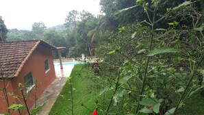 A house with a tiled roof, a swimming pool, and a lush green garden. - HOUSE, FARM, SITE, VERY GREEN 60 KM FROM SPAULO  (Santa Isabel)