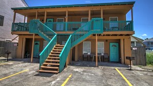 A two-story building with a central staircase and a balcony on the upper floor. - Oleander Beach Lodge - Four Condos for One Great Price (South Padre Island)