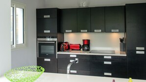 Una cocina moderna con armarios oscuros, una encimera blanca y un cuenco verde.