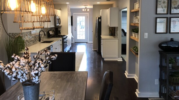 A modern kitchen with a dining area, featuring a wooden table, chairs, and a hanging light fixture. - Beautiful Updated/Decorated Quaint Cottage in the Heart of Fredericksburg (Fredericksburg)