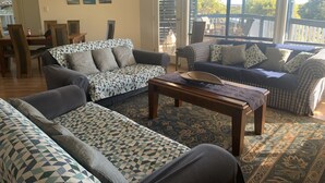 Una sala de estar con dos sofás, una mesa de centro y un comedor con sillas y una mesa.