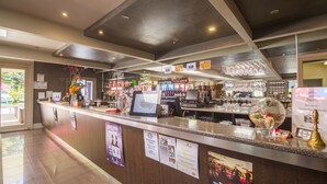Eine Bar mit einer Theke, verschiedenen Flaschen und einer Speisekarte.
