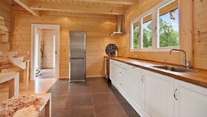Eine moderne Küche mit Holzwänden und einem Edelstahl-Kühlschrank.