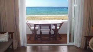 Een kamer met uitzicht op het strand door een geopende deur.