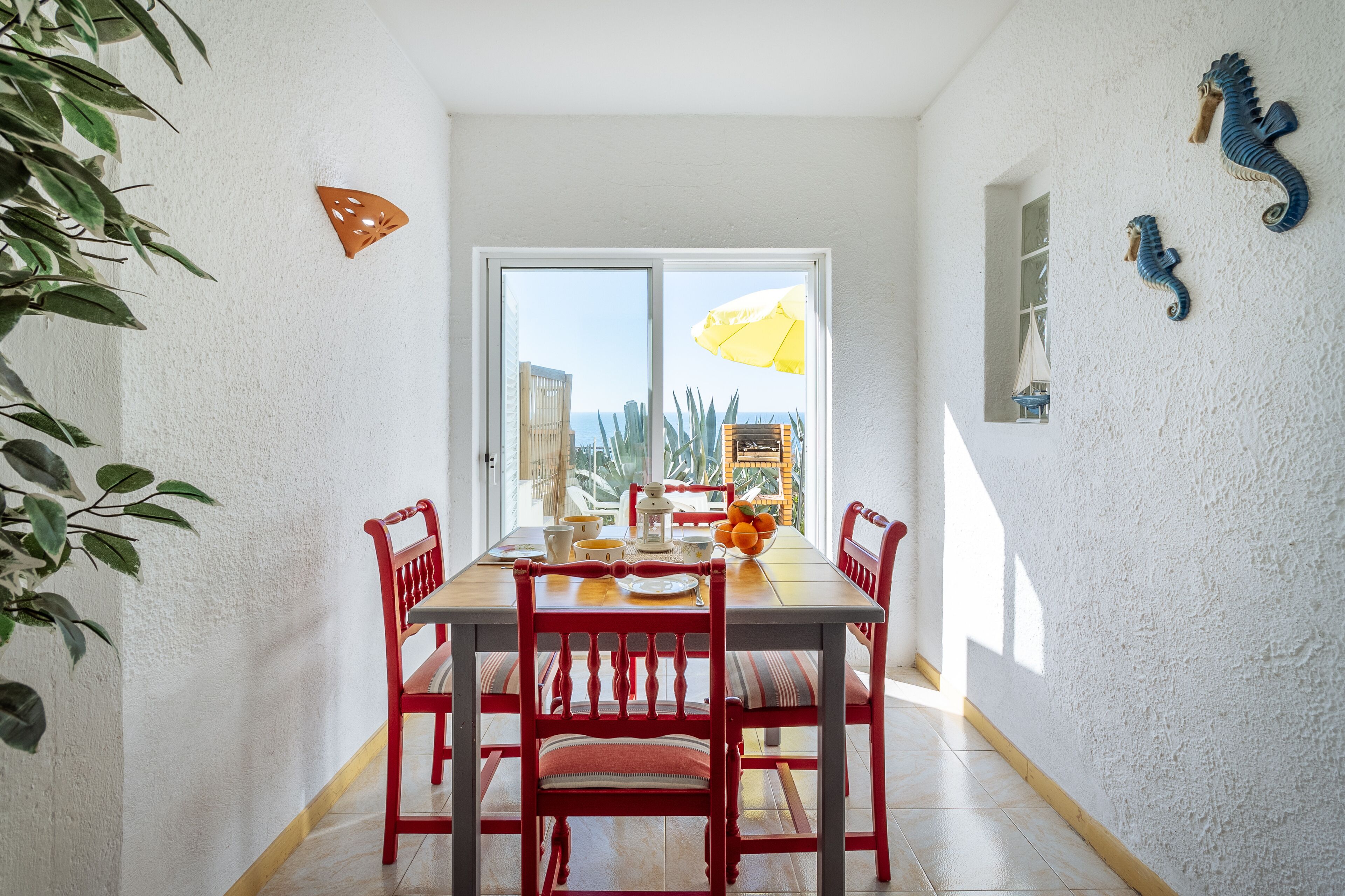 Een eetgedeelte met een tafel, stoelen en uitzicht door een glazen deur.
