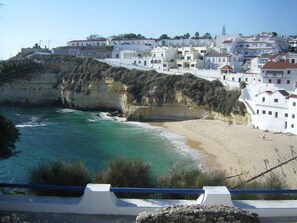 Eine Küstenstadt mit weißen Häusern, einem Strand und Klippen.