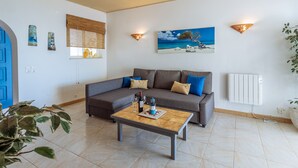 A living room with a sofa, coffee table, and wall art. - Apartment Isabel (Carvoeiro)