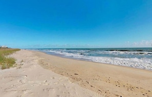 Enjoy a serene beach experience with gentle waves lapping at the shore.