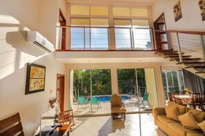 Ein geräumiger Wohnbereich mit Balkon, Pool und Essbereich.