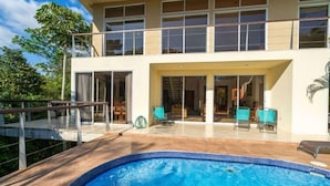 Un bâtiment à deux étages doté d’une piscine, d’un espace extérieur aménagé et d’un patio couvert.