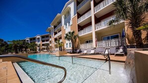 Un hôtel doté d’une piscine, de plusieurs balcons et de palmiers.
