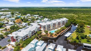 A resort with multiple buildings, a swimming pool, and a river. - Very Spacious, 2 Master Suites, easy walk to the beach, The Best MB pool! (Mexico Beach)