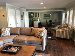 A living room with a sofa, armchairs, a coffee table, and a dining area with a table and chairs.