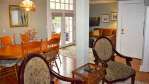 A dining area with a wooden table and chairs, a glass coffee table, and a chandelier. - The Heart of Manitou Springs. Award-winning. Luxurious. Historic. 1st Floor unit (Manitou Springs)