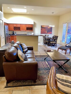 A living room with a brown leather sofa, a coffee table, and a patterned rug. - Starr Pass Escape 3 Bedroom (TUCSON)