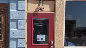 A red door with the number 582, a small window, and a security camera above it.