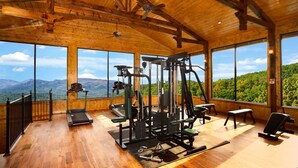 Une salle de sport dotée de planchers en bois et de grandes fenêtres donnant sur un paysage montagneux.
