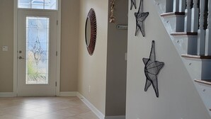 A spacious interior with a staircase, a chandelier, and decorative wall art. - Paradise in Rehoboth.  Beautiful & spacious home -  August dates available. (Rehoboth)