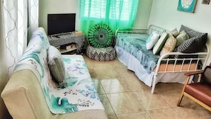 A cozy living room with a sofa, a bed, and a TV. - Casa Menta in Rincon, Puerto Rico (Rincon)