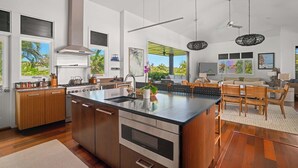 Una cocina amplia con una isla grande, armarios de madera y vistas al exterior.