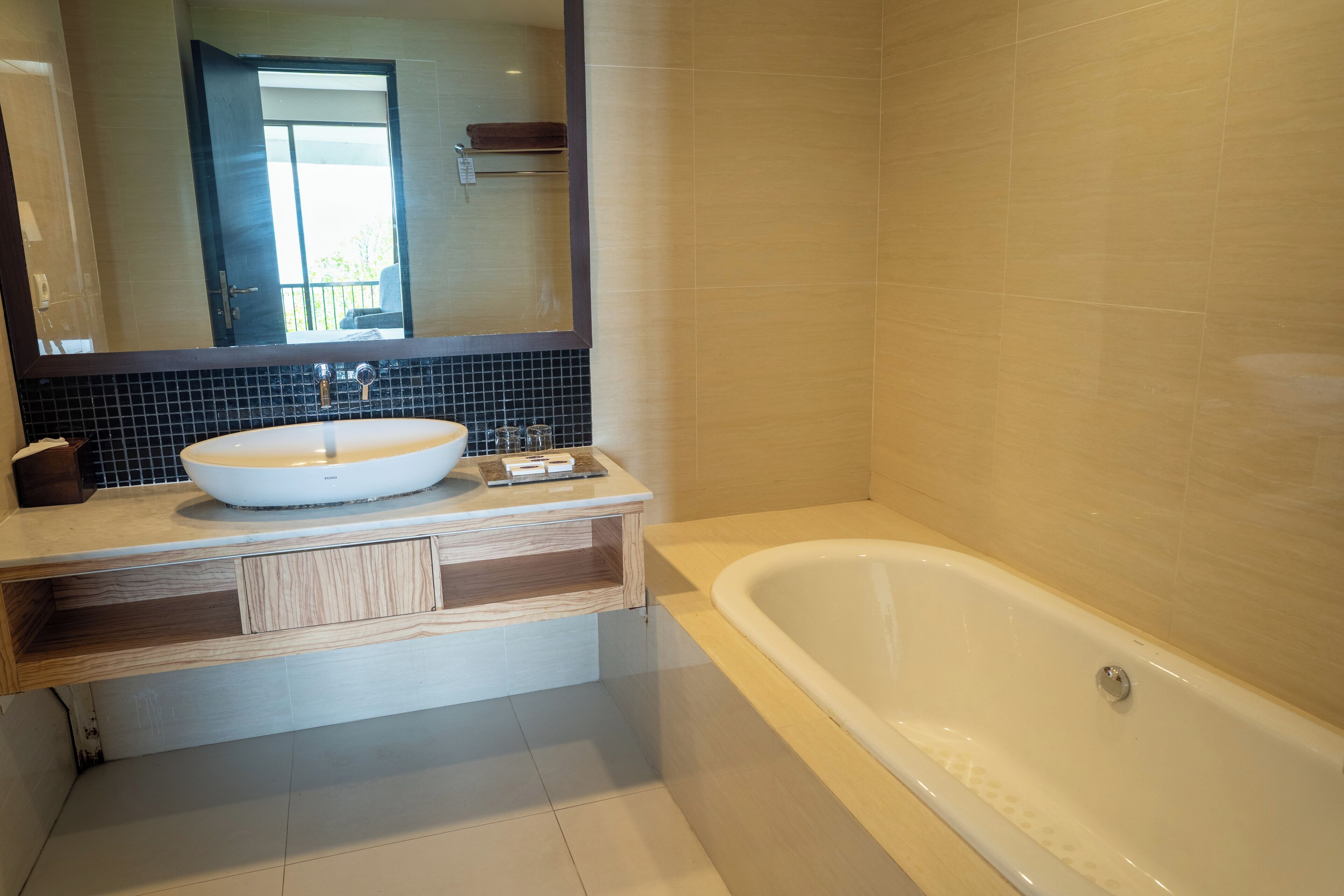 Un bagno moderno con una grande vasca, un lavandino rotondo e uno specchio sopra il lavandino.