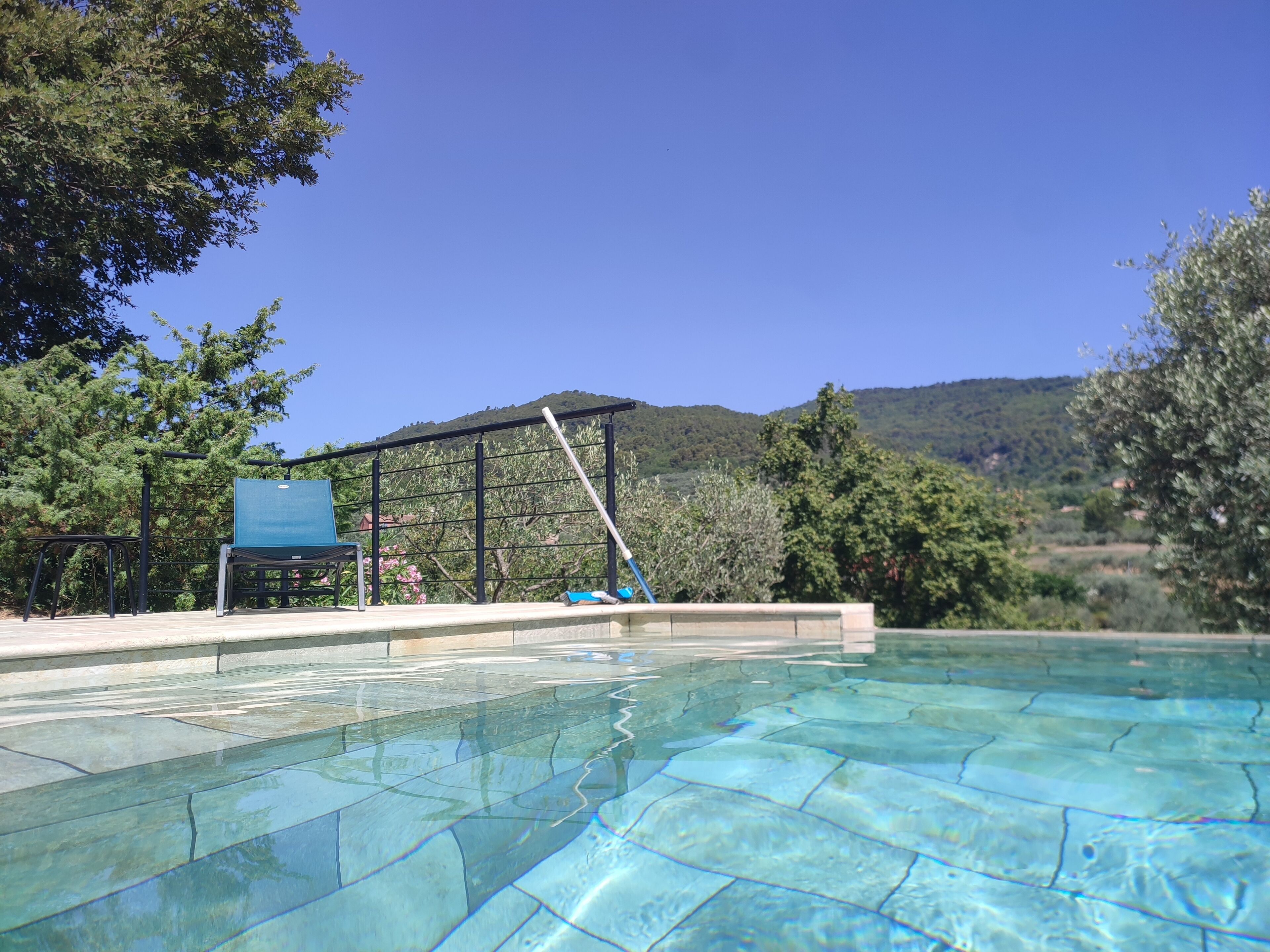 Une piscine aux eaux cristallines offrant une vue sur un paysage montagneux.