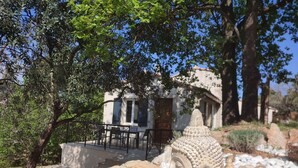 A serene outdoor seating area with a Buddha statue, surrounded by rocks and trees. - La Bastide des Oliviers.charming villa in a peaceful setting with swimming pool
 (callas)