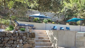 A stone staircase leading to a seating area with outdoor furniture and umbrellas. - La Bastide des Oliviers.charming villa in a peaceful setting with swimming pool
 (callas)