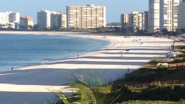 Ein Strand mit einer Reihe hoher Gebäude im Hintergrund.