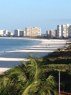 A beach with a row of high-rise buildings in the background.
