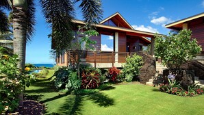 A modern house with a wooden deck, surrounded by tropical plants and a clear view of the ocean. - Hale Makai By Parrish Kauai- oceanfront with pool and AC, honeymoon haven at Hal (Koloa)