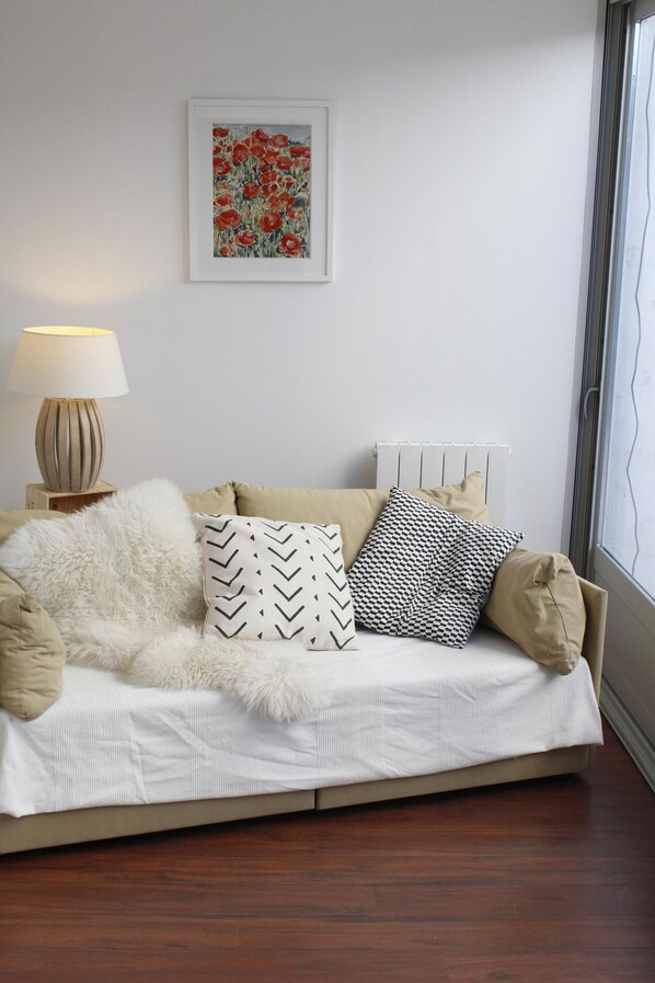 A cozy room with a bed, a lamp, and a framed artwork on the wall.