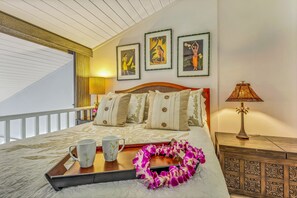 A neatly made bed with a tray of breakfast items, a decorative lei, and framed artwork on the wall. - Gorgeous Updated Oceanfront Condo 2BR /2BA AMAZING Molokai Views~Hale Honu (Lahaina)