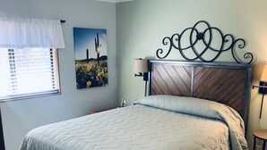 A bedroom with a bed, a window with blinds, a wall-mounted picture, and a decorative metal headboard. - Rim Country Living in the heart of Arizona (Payson)