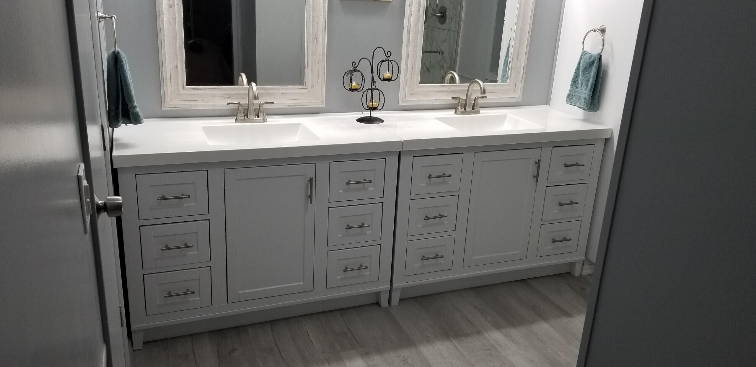 A bathroom with two sinks, a mirror, and a cabinet with drawers.