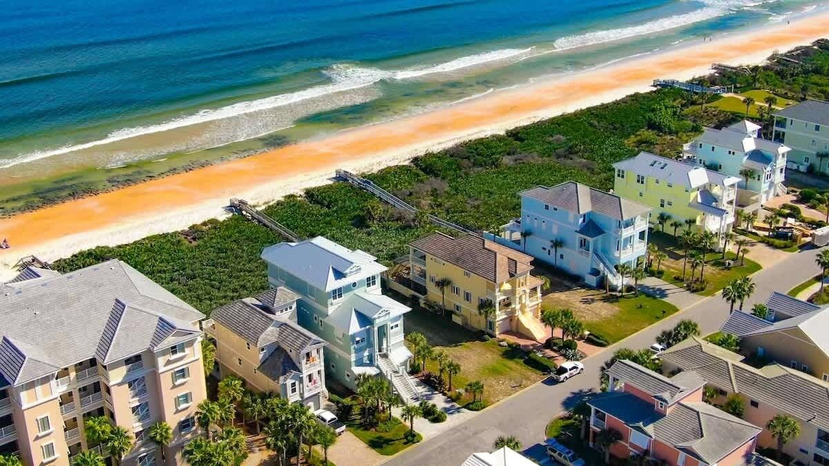 A coastal residential area with beachfront properties, including multi-story buildings and a beach access road.