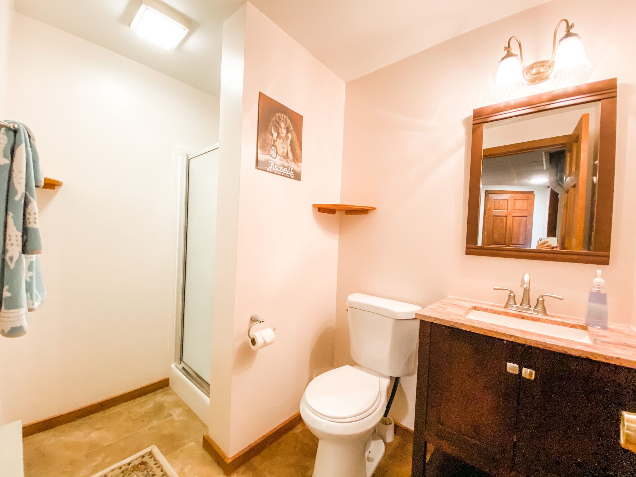 Une salle de bain avec des toilettes, un lavabo et une douche.