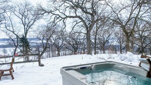 A hot tub in a snowy outdoor setting with a view of trees and a distant landscape. - Beautiful compound, 10 mile views, on 300 acre ranch, next to Galena Territory (Elizabeth)